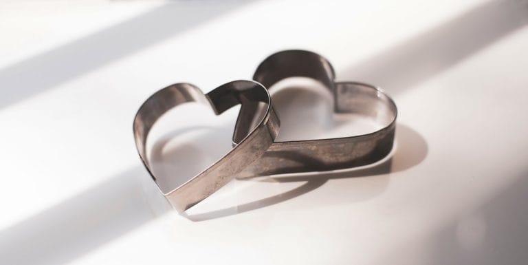 Heart-shaped metal cookie cutters on a white surface.